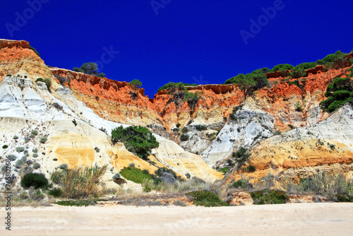 Red rocks on Rock Algarve Praia da Falesia in Portugal with nice blue sky to take a long beach walk, have some fun for beach games, to swim and to chill out. 