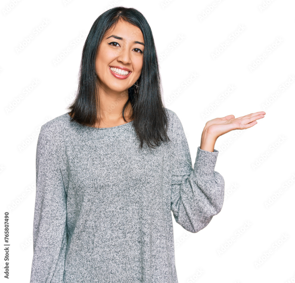 Beautiful asian young woman wearing casual clothes smiling cheerful presenting and pointing with palm of hand looking at the camera. Beautiful asian young woman wearing casual clothes smiling cheerful presenting and pointing with palm of hand looking at the camera.