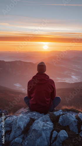Man meditating at sunrise on a mountaintop  a view of the horizon  soft diffused light  a thoughtful and serene mood. 