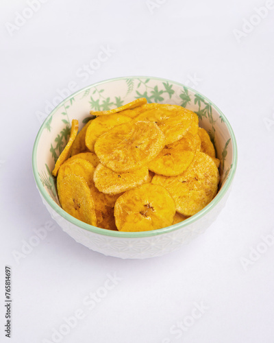 Green banana chips on white background