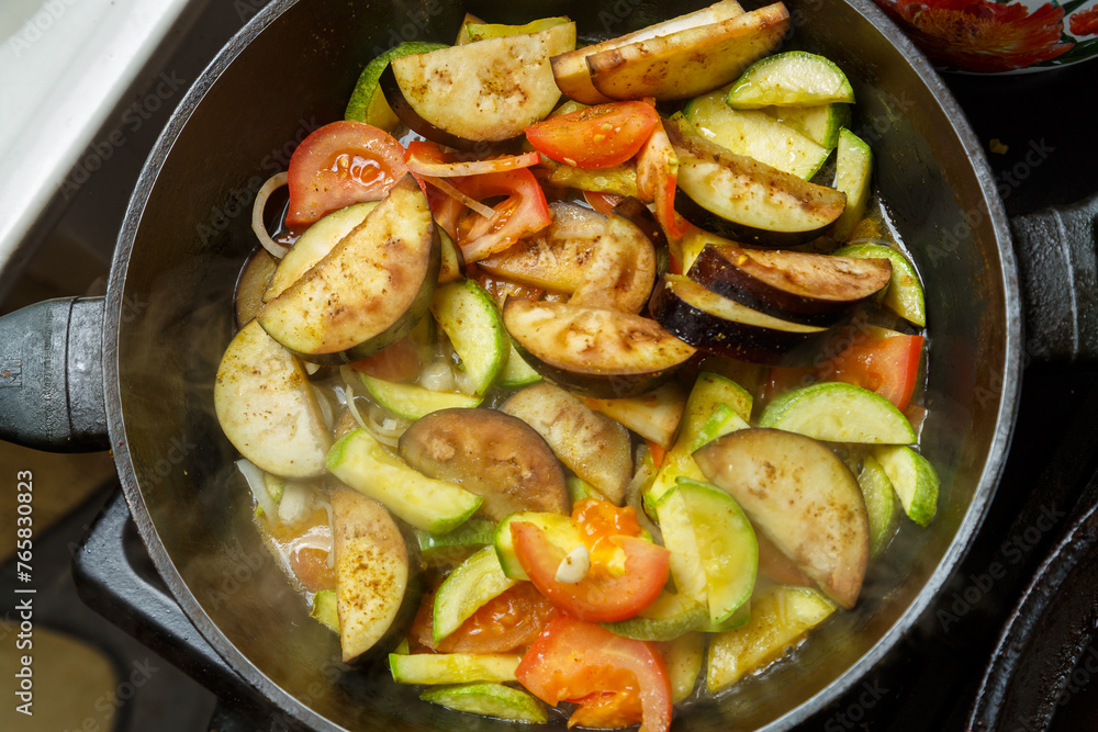 Vegetables fried in spices in a frying pan in oil on the stove Vegetables fried in spices in a frying pan in oil on the stove