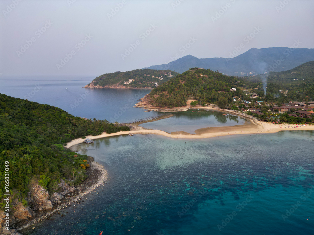 Aerial drone view small Koh Ma island, Ko Phangan Thailand. Exotic coast panoramic landscape, Mae Haad beach, summer day. Sandy path between corals. Vivid seascape, mountain coconut palms from above.