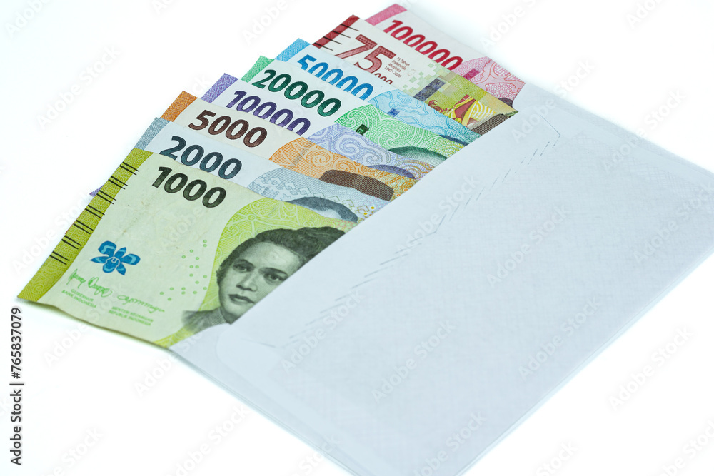Indonesian currency. Stack of Rupiah or IDR banknotes inside white envelope on white background Indonesian currency. Stack of Rupiah or IDR banknotes inside white envelope on white background