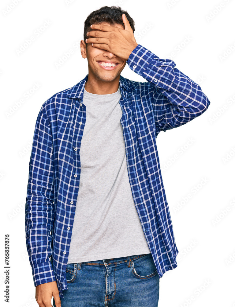 Young handsome african american man wearing casual clothes smiling and laughing with hand on face covering eyes for surprise. blind concept. Young handsome african american man wearing casual clothes smiling and laughing with hand on face covering eyes for surprise. blind concept.