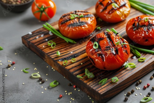 Board with tasty grilled tomatoes and green onion, onion, and tasty grilled tomatoes