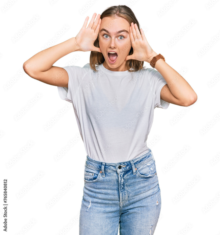 Beautiful young blonde woman wearing casual white t shirt smiling cheerful playing peek a boo with hands showing face. surprised and exited Beautiful young blonde woman wearing casual white t shirt smiling cheerful playing peek a boo with hands showing face. surprised and exited