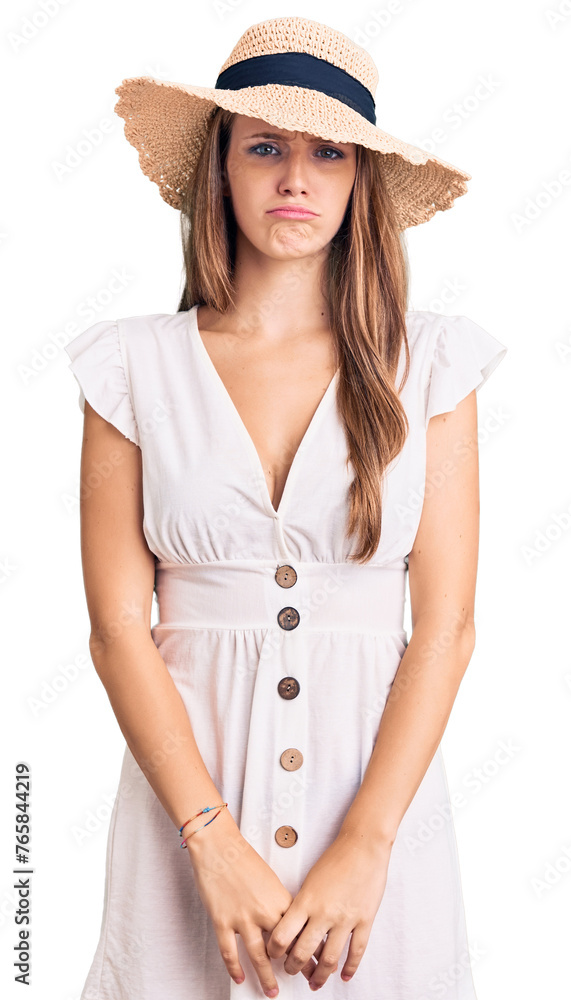 Young beautiful blonde woman wearing summer dress and hat depressed and worry for distress, crying angry and afraid. sad expression. Young beautiful blonde woman wearing summer dress and hat depressed and worry for distress, crying angry and afraid. sad expression.