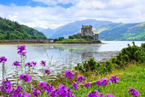 Eilean Donan Castle in the highlands of Scotland, UK. Beautiful flowers and reflections.