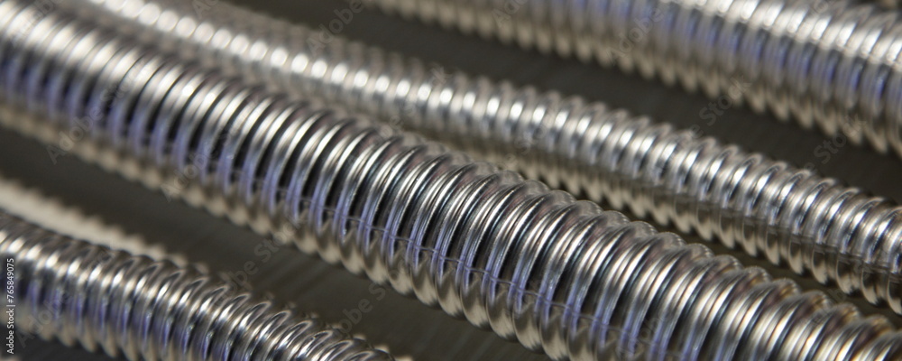 A many shiny Stainless steel sylphon corrugated pipes technical metal background texture