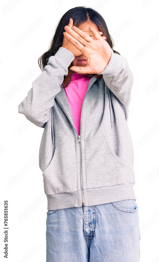 Young beautiful mixed race woman wearing casual sporty clothes covering eyes with hands and doing stop gesture with sad and fear expression. embarrassed and negative concept. Young beautiful mixed race woman wearing casual sporty clothes covering eyes with hands and doing stop gesture with sad and fear expression. embarrassed and negative concept.