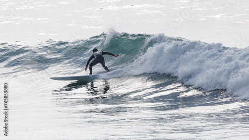 Photography A male surfer riding a wave  at Polzeath in Cornwall