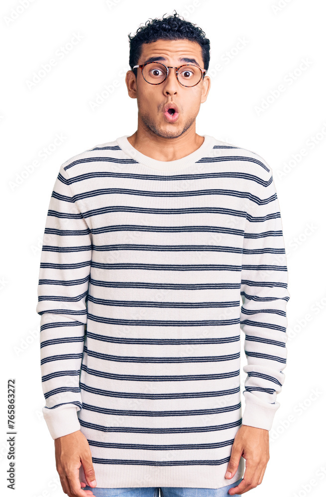 Hispanic handsome young man wearing casual clothes and glasses afraid and shocked with surprise expression, fear and excited face. Hispanic handsome young man wearing casual clothes and glasses afraid and shocked with surprise expression, fear and excited face.