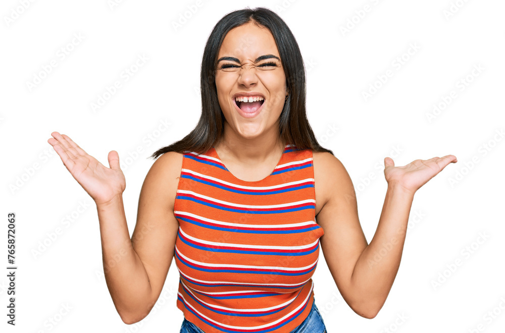Young brunette woman wearing casual clothes celebrating mad and crazy for success with arms raised and closed eyes screaming excited. winner concept Young brunette woman wearing casual clothes celebrating mad and crazy for success with arms raised and closed eyes screaming excited. winner concept