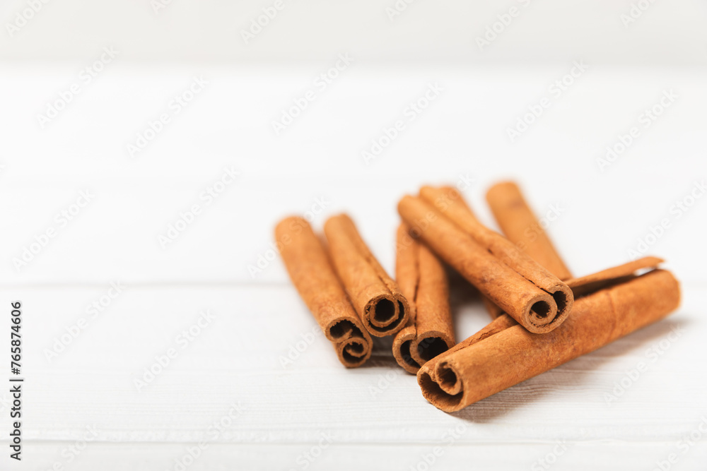 Cinnamon sticks on a textured wooden background. Cinnamon roll. Spicy spice for baking, desserts and drinks. Fragrant ground cinnamon. cinnamon powder Close-up. Place for text. copy space Cinnamon sticks on a textured wooden background. Cinnamon roll. Spicy spice for baking, desserts and drinks. Fragrant ground cinnamon. cinnamon powder Close-up. Place for text. copy space