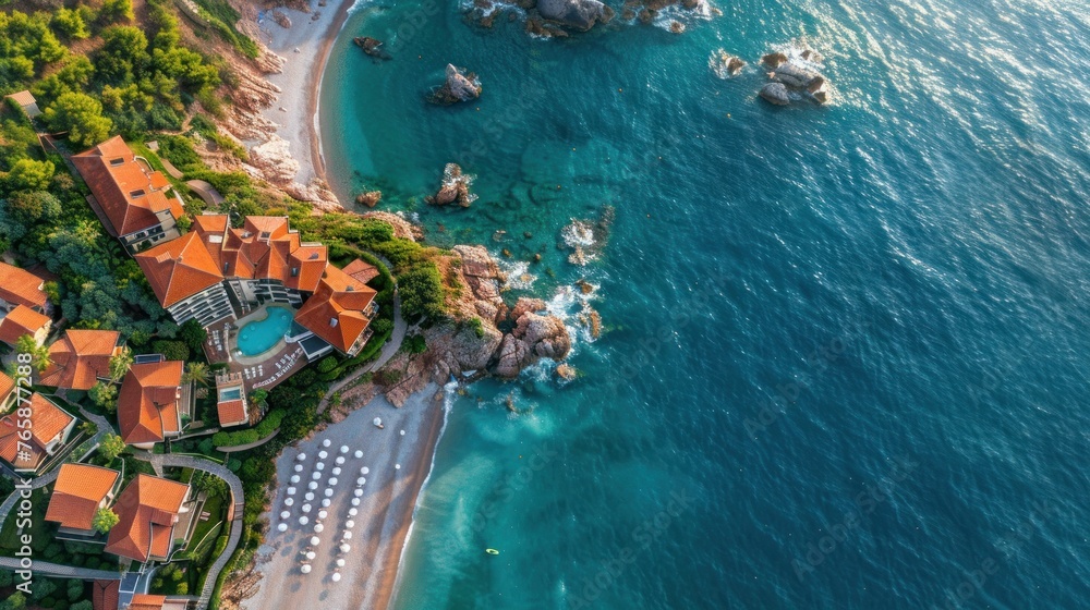 Aerial view A luxury hotel on the sea coast with clear blue water, boats, pier, hotel and green trees in summer on a sunny day