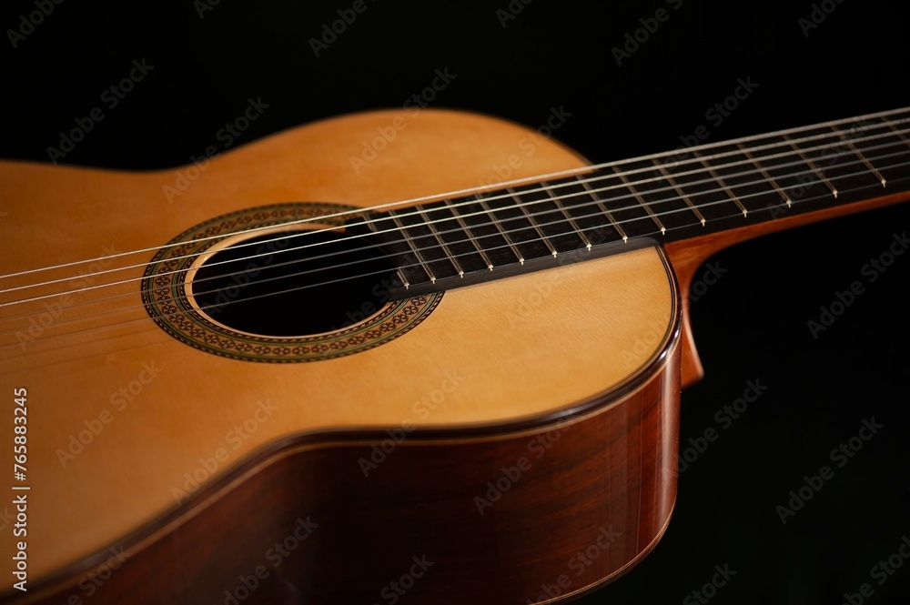 Classical Spanish flamenco guitar close up, dramatically lit isolated on black background with copy space. Classical Spanish flamenco guitar close up, dramatically lit isolated on black background with copy space.