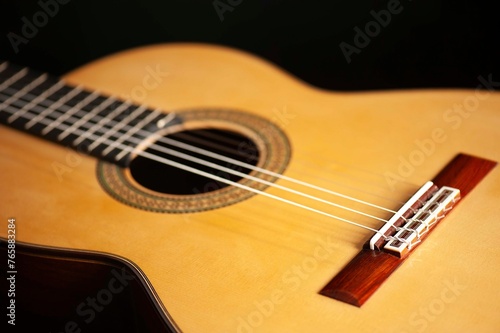 Classical Spanish flamenco guitar close up, dramatically lit isolated on black background with copy space.