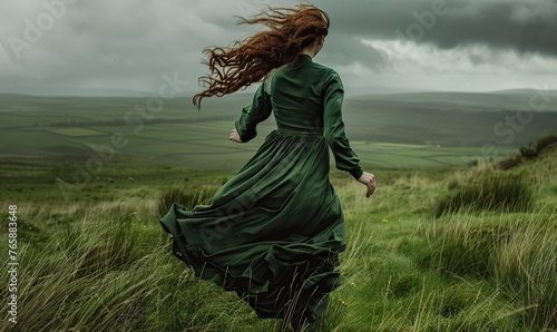 Woman in a Green Dress Running Across Grassy Meadow photo