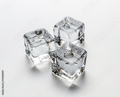 Three transparent ice cubes melting on a white surface background