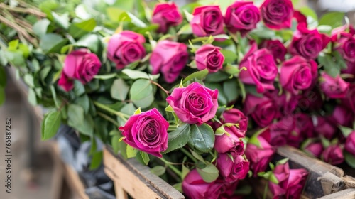  a bunch of pink roses sitting in a wooden crate with green leaves on the outside of the box and on the inside of the box. © Olga