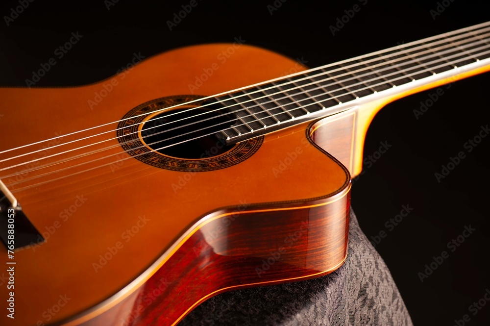 Classical Spanish flamenco guitar close up, dramatically lit isolated on black background with copy space. Classical Spanish flamenco guitar close up, dramatically lit isolated on black background with copy space.