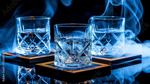  a set of three glasses sitting on top of a wooden table covered in blue and white smoke and smokestacks. © Olga