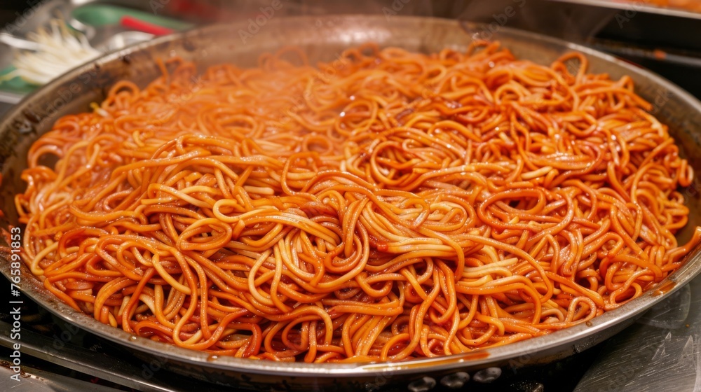  a pan filled with noodles sitting on top of a stove next to a frying pan with noodle in it.