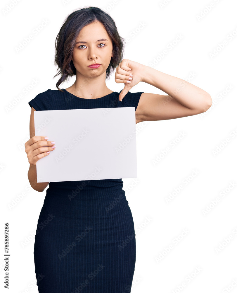 Young beautiful girl holding blank empty banner with angry face, negative sign showing dislike with thumbs down, rejection concept Young beautiful girl holding blank empty banner with angry face, negative sign showing dislike with thumbs down, rejection concept