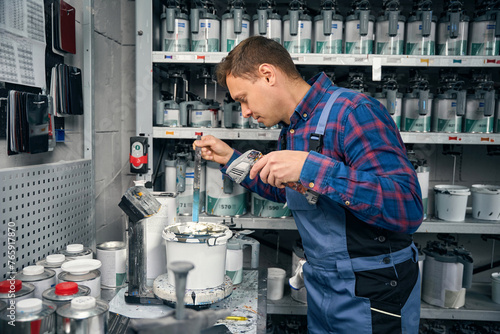 Фотография Mechanic selection and mixing of colors for car painting