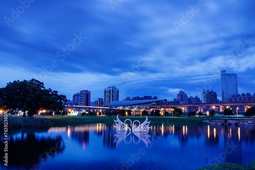 Peaceful scenery and reflections during the blue hour before sunrise in early summer near the Sanchong Station of Taoyuan Airport MRT in the New Taipei City Metropolitan Park. 
