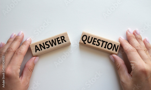 Answer or Question symbol. Concept word Answer or Question on wooden blocks. Businessman hand. Beautiful white background. Business and Answer or Question concept. Copy space