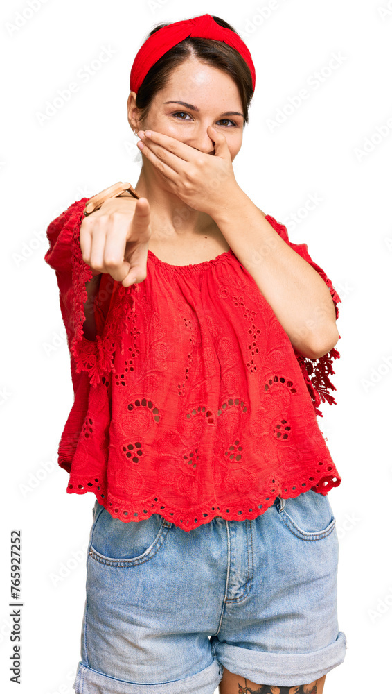 Young brunette woman with short hair wearing casual summer clothes and diadem laughing at you, pointing finger to the camera with hand over mouth, shame expression Young brunette woman with short hair wearing casual summer clothes and diadem laughing at you, pointing finger to the camera with hand over mouth, shame expression