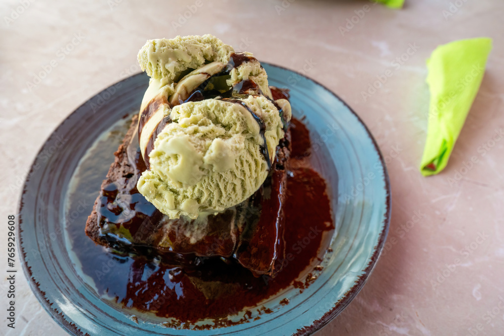 Warm Chocolate brownie cake with hot fudge sauce and vanilla ice cream on top view