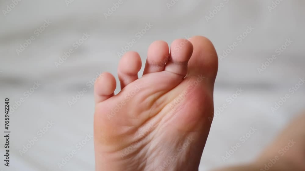 The foot of child close-up. Beautiful moving toes. Small tender healthy sole of kid. White soft skin. Physiotherapy after fracture or sprain. Part of the body. Slow motion. High quality 4K The foot of child close-up. Beautiful moving toes. Small tender healthy sole of kid. White soft skin. Physiotherapy after fracture or sprain. Part of the body. Slow motion. High quality 4K