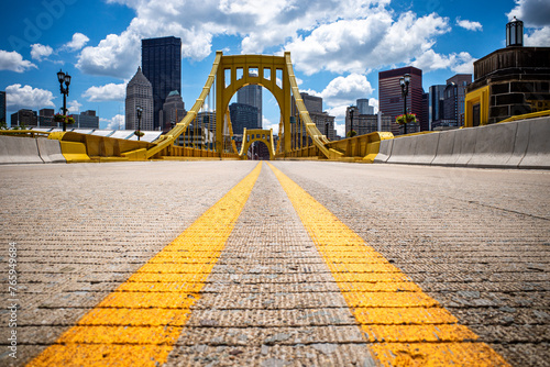 Rachel Carson Bridge close to the road surface with markings and yellow bridge and downtown Pittsburgh behind. photo