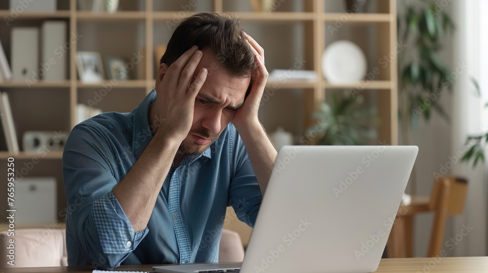 Side profile view man sitting at desk, holding head in hands, looking at laptop screen in despair. A male worker accidentally deletes important data or can't fix computer error and program malfunction Side profile view man sitting at desk, holding head in hands, looking at laptop screen in despair. A male worker accidentally deletes important data or can't fix computer error and program malfunction