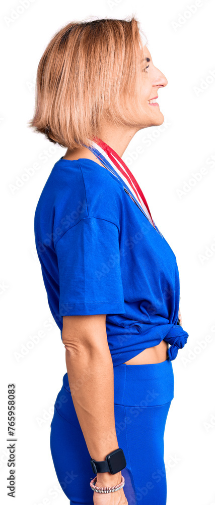 Fototapeta premium Young blonde woman wearing winner medals looking to side, relax profile pose with natural face with confident smile.