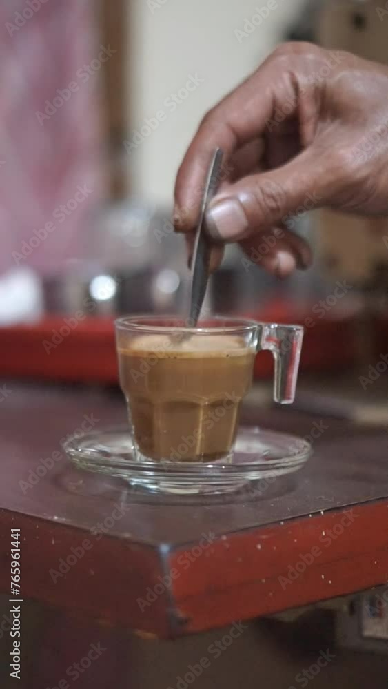 beautiful vertical video shot of a cup of milk coffee stirred in a white glass cup on a table beautiful vertical video shot of a cup of milk coffee stirred in a white glass cup on a table