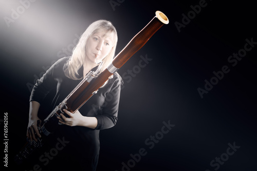 Bassoon woodwind instruments player. Classical musician woman playing orchestral bass