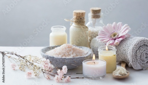 Background with different bottles of cosmetics, ingredients, candles, flowers, and organic extracts for spa procedures and beauty treatment