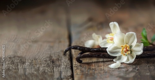vanilla beans and flowers close up on wooden table, banner with copy space