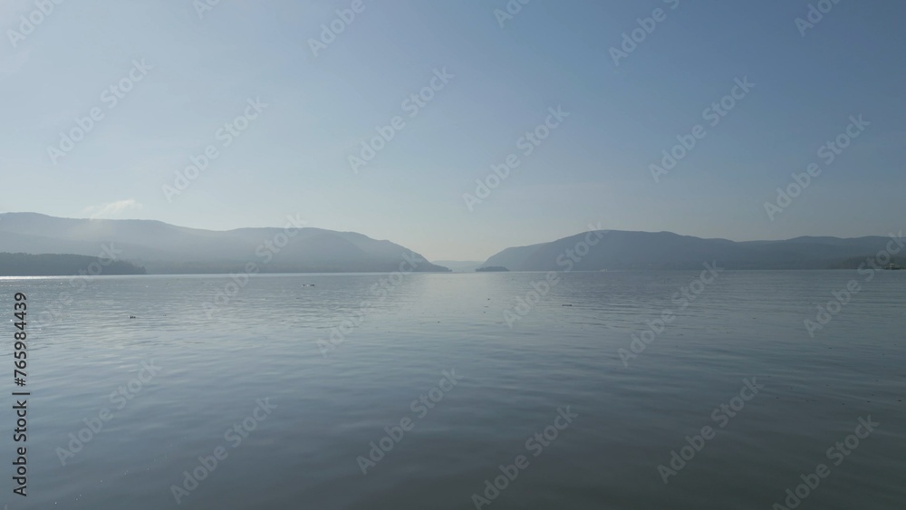 Hazy lake with mountains in the distance on a beautiful sunny morning Hazy lake with mountains in the distance on a beautiful sunny morning