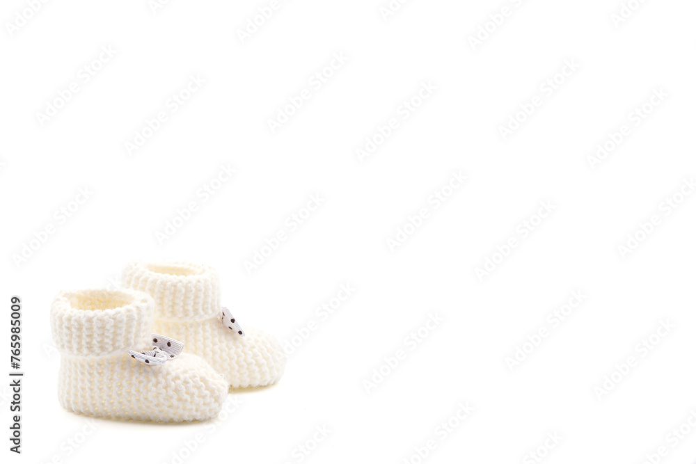 White crochet baby booties with black polka dot bows isolated on a white background. Handmade baby booties. Photo in high quality White crochet baby booties with black polka dot bows isolated on a white background. Handmade baby booties. Photo in high quality