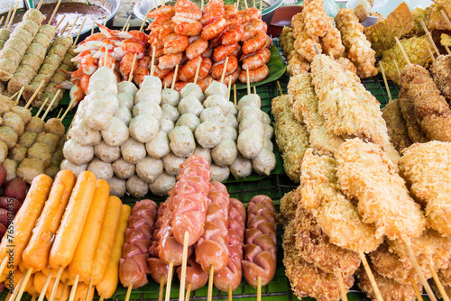 Photography Cooked street food including sausages, prawns,fish balls, pork balls on a stall