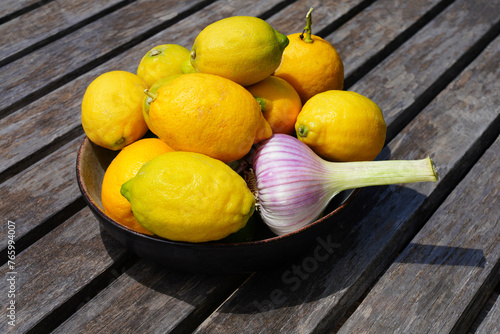 Bowl of fresh lemons with a head of garlic © eqroy