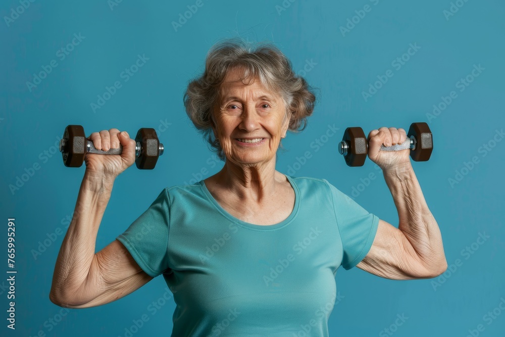 portrait happy an elderly woman does sports with small dumbbells. Free space for text portrait happy an elderly woman does sports with small dumbbells. Free space for text
