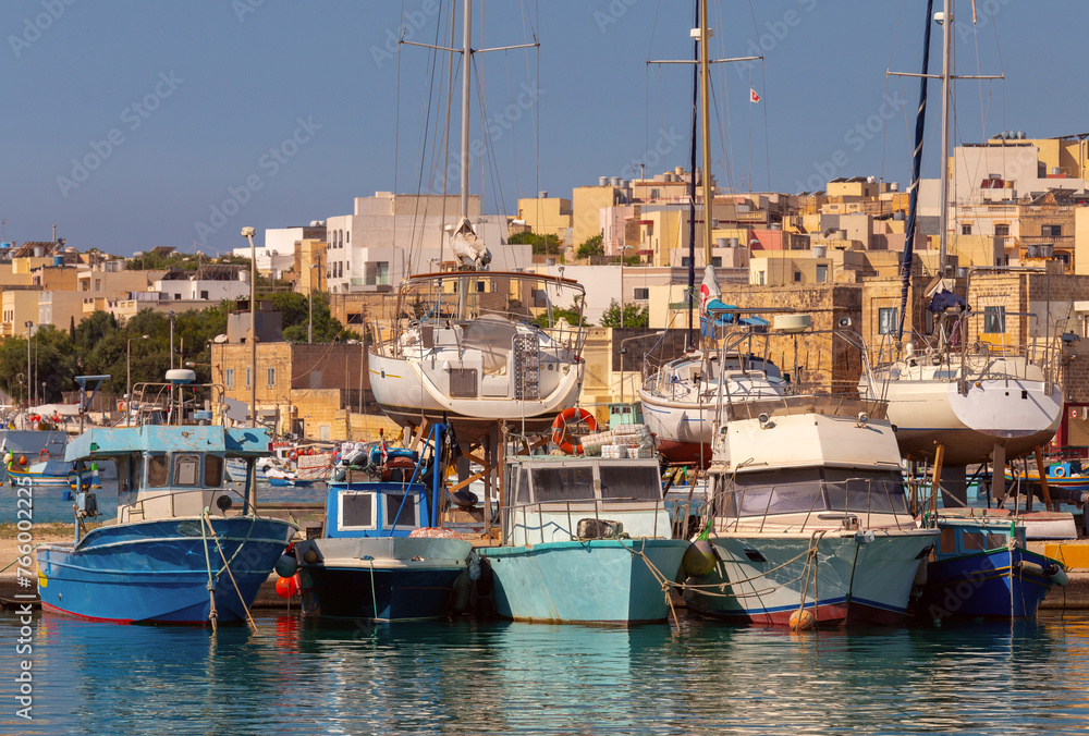 Multi-colored fishing boats luzzi with eyes in the harbor of the village Marsaxlokk on the island Malta.