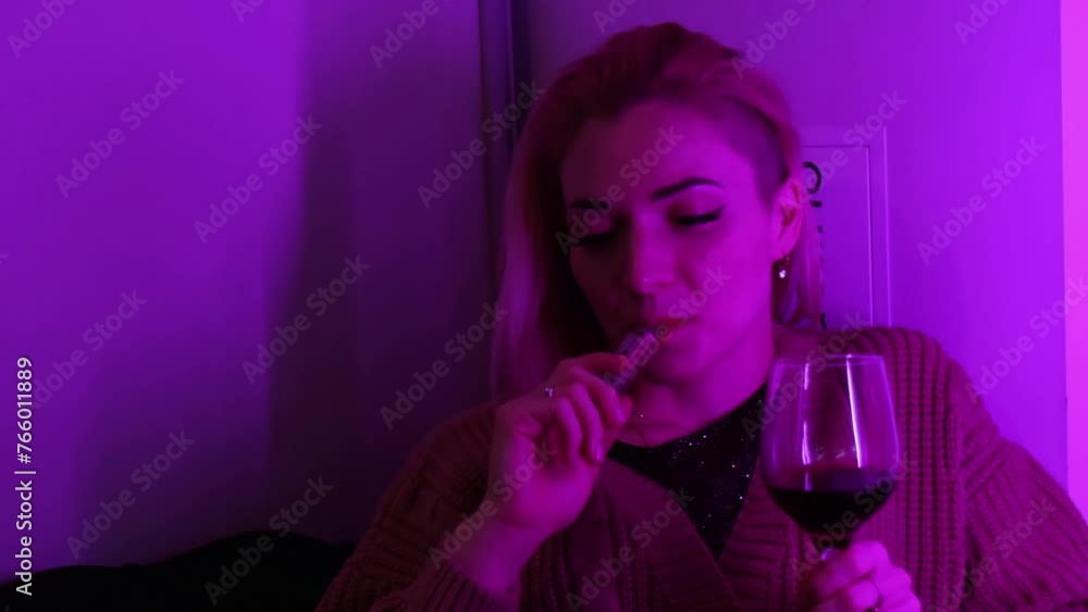 Portrait of calm young lady smoking vape and drink wine Portrait of calm young lady smoking vape and drink wine