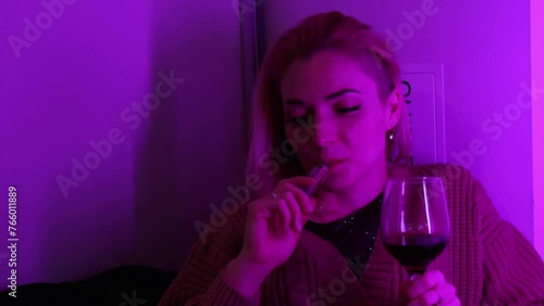 Portrait of calm young lady smoking vape and drink wine