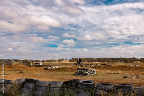 Teen boy riding motorbike at motocross track meet